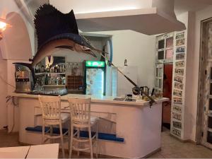 a kitchen with a counter with two chairs and a fish head on the wall at Hotel NEMO in Kiten +160 photos