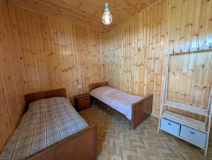 a room with two beds in a wooden cabin at Guest House Roba in Gordi