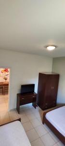 a bedroom with two beds and a dresser and a desk at KANALI HOLIDAYS APARTMENT 2 in Kanali