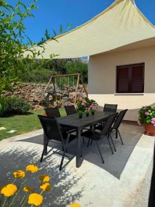 a black table with chairs and flowers on a patio at Jacuzzi House Kaštela - Parking - Playground in Kaštela