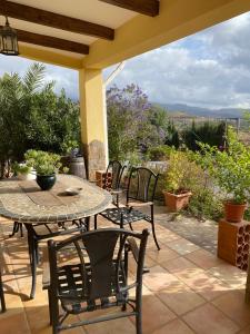 a table and chairs on a patio with a view at Cortijo Estrella in Serón