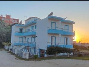 a white building with blue balconies on the side of it at KANALI HOLIDAYS APARTMENT 3 in Kanali