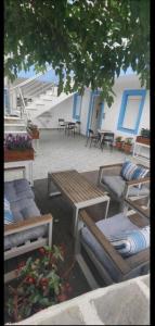 a patio with several benches and tables and a building at KANALI HOLIDAYS APARTMENT 2 in Kanali +3 photos
