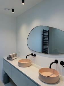 two sinks in a bathroom with a mirror at Casa Mare Boutique in Blankenberge