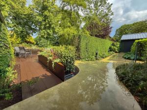 a garden with a patio and plants and a fence at Nisterlo Guesthouse in Nistelrode