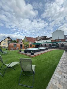 a lawn with two chairs in the middle of it at Franken Chalets in Kist