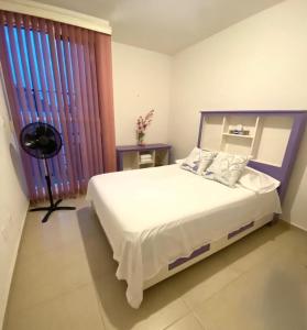 a bedroom with a large white bed and a window at CASASANTA Fe cercalberca Wifi in Alpuyeca
