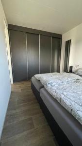 a bedroom with a large bed and a wooden floor at Enkhuizer Strandchalet Nr 257 in Enkhuizen