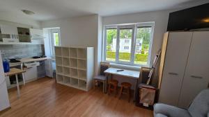 a small kitchen with a table and chairs in it at Hotelik Europa Apartamenty i pokoje gościnne in Unieście