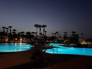 una gran piscina por la noche con luces azules en Oasis Jaylota, en Corralejo 56 fotos más