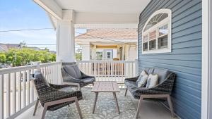 Modern Coastal Comfort - 3 Bedroom Condo with Balcony في أوشن سيتي: شرفة مع كراسي وطاولة على المنزل