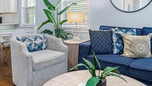 Modern Coastal Comfort - 3 Bedroom Condo with Balcony في أوشن سيتي: غرفة معيشة مع كراسي زرقاء وطاولة