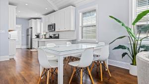 Modern Coastal Comfort - 3 Bedroom Condo with Balcony في أوشن سيتي: مطبخ مع طاولة بيضاء وكراسي بيضاء +24 صورة