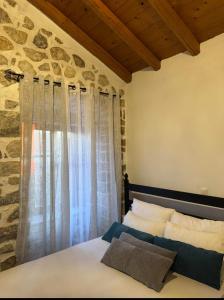 a bedroom with a bed and a stone wall at Lithos Areopoli Traditional House in Areopoli