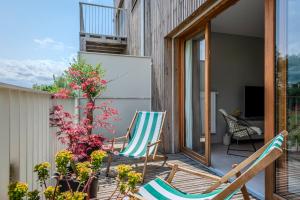 a patio with rocking chairs and flowers on a house at Appartement familial 5 min Disney 30 min Paris in Montévrain