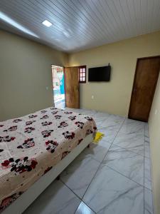 a bedroom with a bed and a flat screen tv at Espaço Vó Margarida in Caruaru
