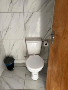 a white toilet in a bathroom with marble walls at Espaço Vó Margarida in Caruaru +6 photos
