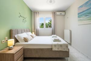 イエラペトラにあるSunset Apartmentの大きなベッドと窓のある寝室