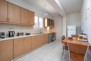a kitchen with wooden cabinets and a table in it at Sunset Apartment in Ierapetra