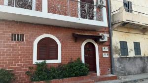 a brick building with two doors and a balcony at Lindsey House in Saint-Louis