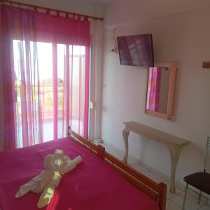 a teddy bear laying on a bed in a bedroom at House Mantesos in Koinyra