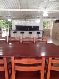 una gran mesa de madera con sillas y una cocina en FINCA SAN JAVIER GREAT FARM WITH HORSES AND POOl, en Sasaima