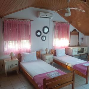 a bedroom with two beds and a mirror at House Mantesos in Koinyra