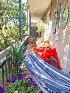 a blue hammock on a porch with flowers at Casa Orso in Abbadia Lariana