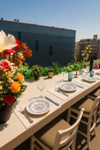 un lungo tavolo con piatti, bicchieri e fiori di Old Town apartment with Amazing View from the Balcony a Bucarest