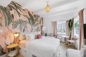 a bedroom with a white bed with a tropical wallpaper at Le Particulier Miami in Miami Beach +17 photos