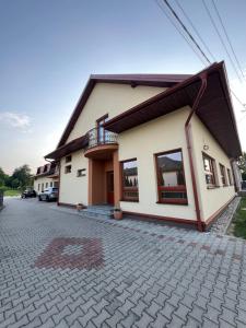 a house with a balcony on the side of it at Ubytovanie PLATAN in Bartošovce