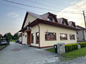 a white house with a brown roof at Ubytovanie PLATAN in Bartošovce