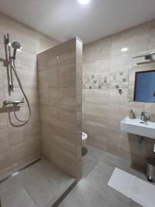 a bathroom with a shower and a toilet and a sink at Ubytovanie PLATAN in Bartošovce