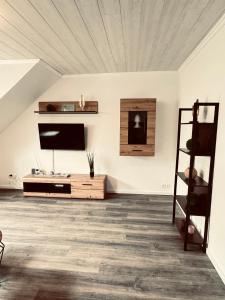 a living room with a flat screen tv on the wall at Apartment 5 - Haus Heinke am Deich in Friedrichskoog-Spitz