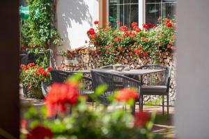 a table and chairs in front of a wall of flowers at Hotel Pettneuerhof in Pettneu am Arlberg