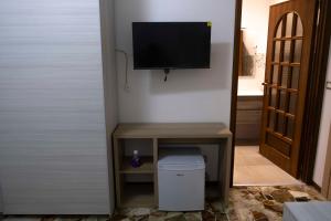 a room with a television on a wall with a trash can at Sentiti a casa in Bronte