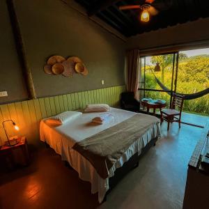 Un dormitorio con una cama y una ventana grande. en Villa Verde Pousada Gastronômica, en Bom Jesus dos Perdões