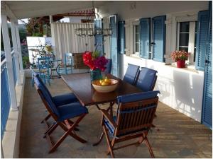 a wooden table with chairs and a bowl of fruit on a patio at 1-bedroom apartment in Finikounta