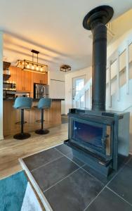 a fireplace in a living room with a stove at Le Repère du Mont-Saint-Anne in Beaupré