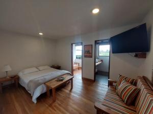 ラ・セハにあるHotel Campestre Ronda Ecuestre Rionegroのベッドとテーブルとソファのある寝室