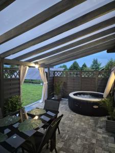 a patio with a hot tub and a table and chairs at Apartamenty Gajewscy in Lipnica Górna