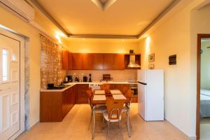 a kitchen with a table and a white refrigerator at Themis Home in Mesimvría