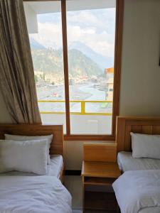a room with two beds and a large window at Beach Resort in Kalām