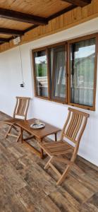 two chairs and a wooden table on a porch at Casa de vacanta Musatesti in Robaia