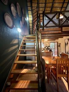 a staircase in a room with a table and plates on the wall at Tranquil Bush Cottage at Kruger in Marloth Park