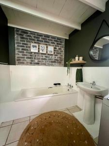 a bathroom with a bath tub and a sink at Tranquil Bush Cottage at Kruger in Marloth Park