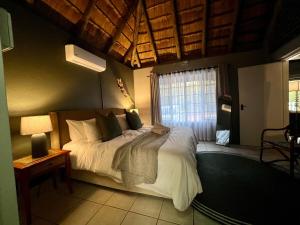 a bedroom with a large bed with a window at Tranquil Bush Cottage at Kruger in Marloth Park