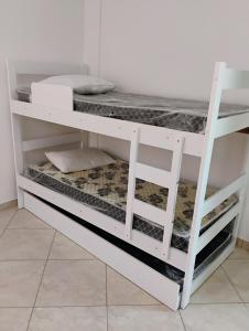 a white bunk bed with a ladder in a room at AP térreo-Rio das Ostras próx Enseada -Costazul in Rio das Ostras