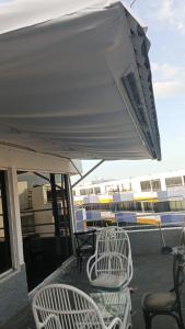 eine Gruppe von Stühlen und ein Sonnenschirm auf einer Terrasse in der Unterkunft Coral Plaza Lechería Vacaciones cerca de playa in El Morto de Barcelona + 12 Fotos