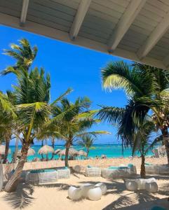 une vue sur une plage avec des palmiers et l'océan dans l'établissement Residencial Oasi Casa, à Boca Chica